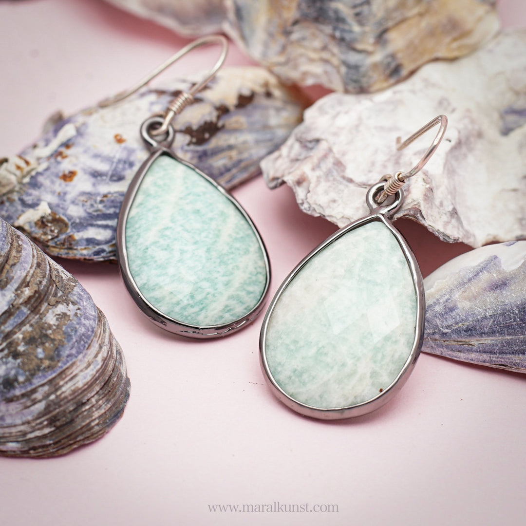 A women shows her ears wearing a pair of sterling silver 925 earrings 