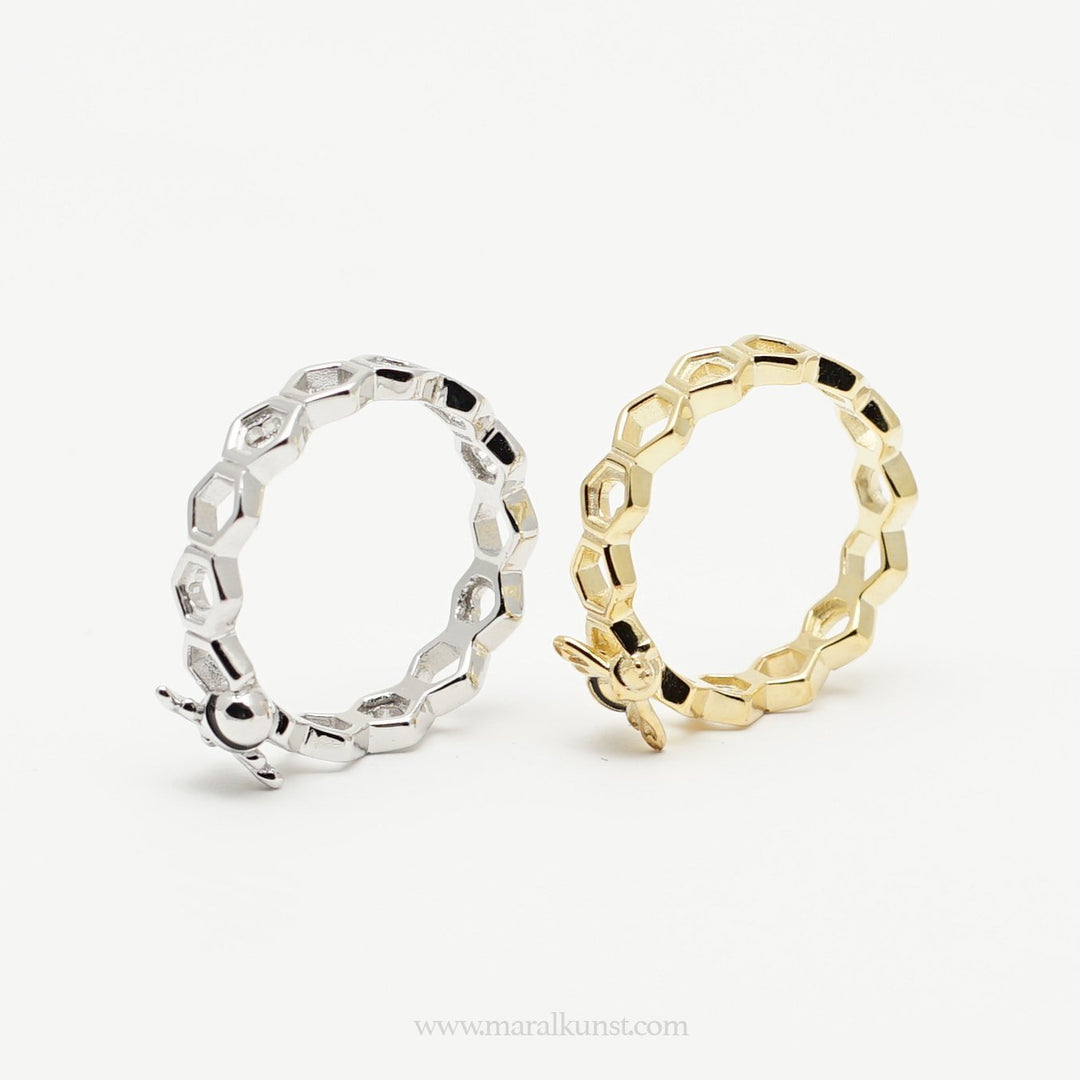 a women hand wearing 2 sterling silver rings have the shape of beehives