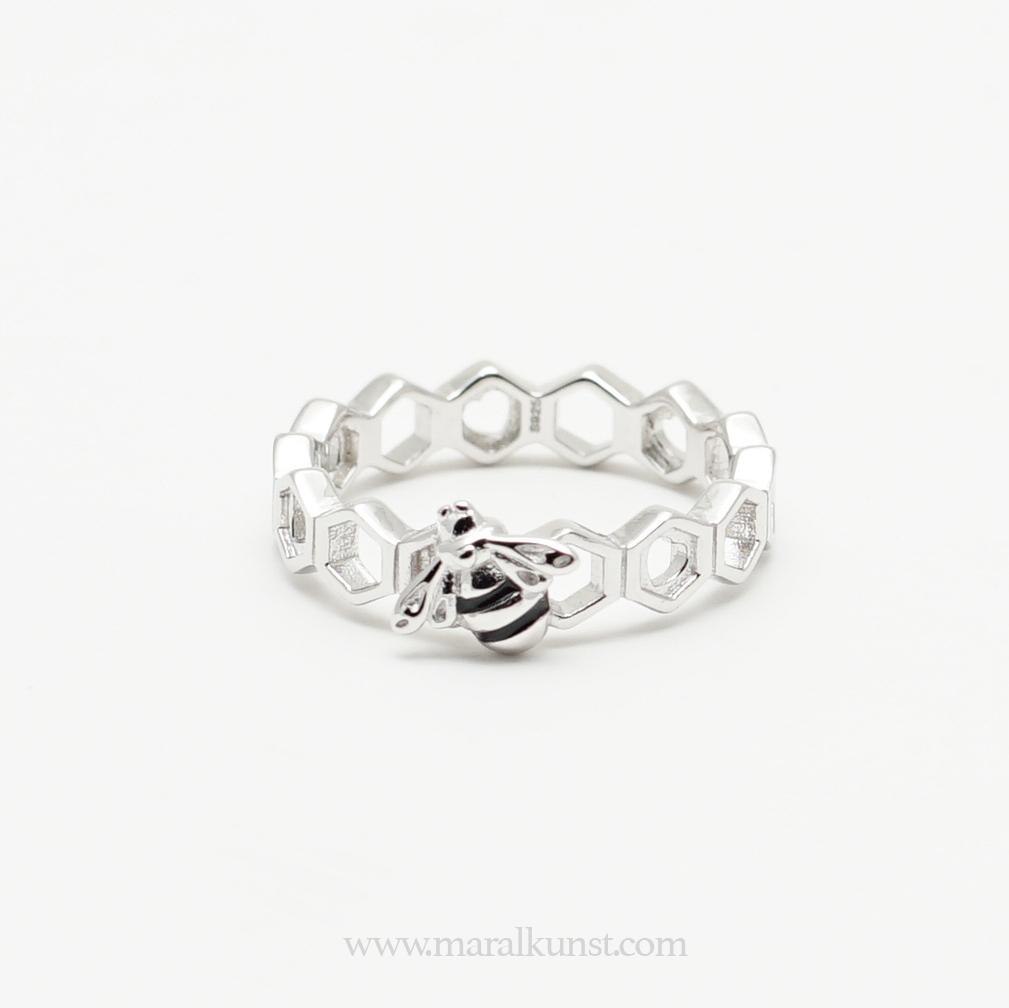 a women hand wearing 2 sterling silver rings have the shape of beehives