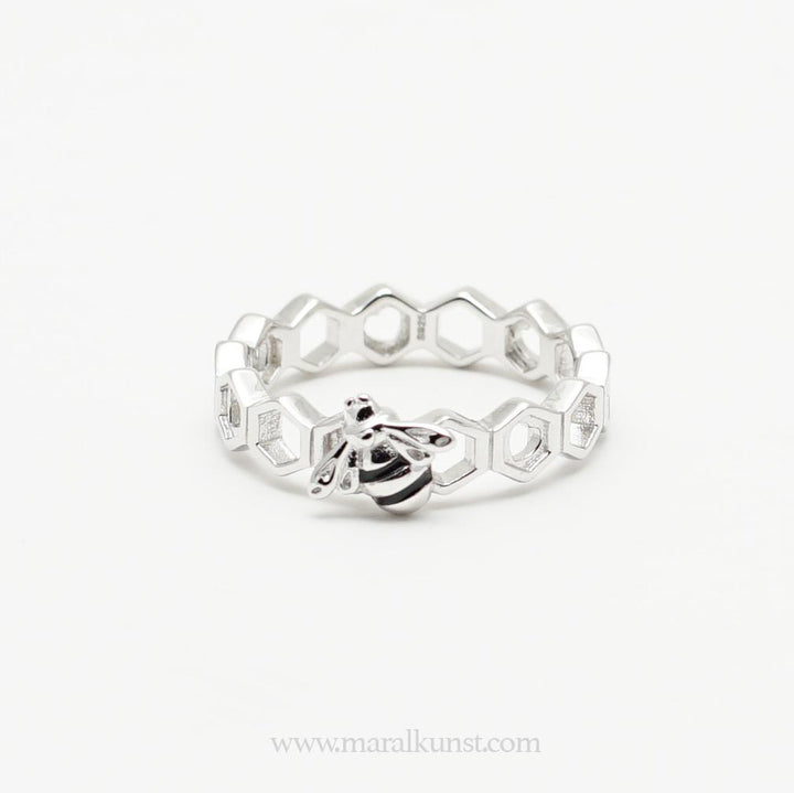 a women hand wearing 2 sterling silver rings have the shape of beehives