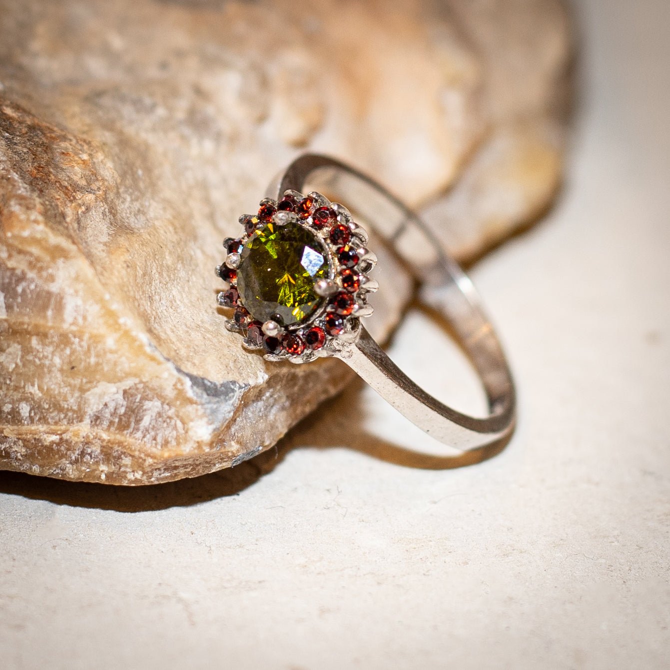 a garnet gemstone ring in sterling silver is laying on a stone