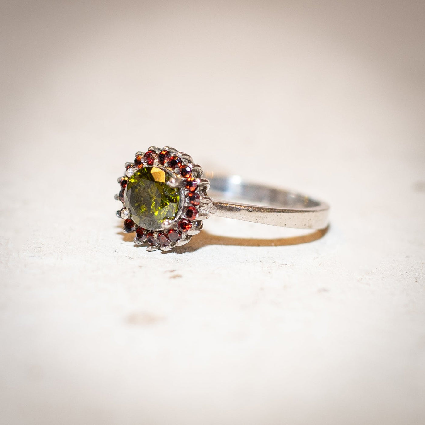 a garnet gemstone ring in sterling silver is laying on a stone