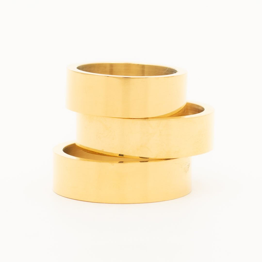 a ring in stainless steel is laying on the white table