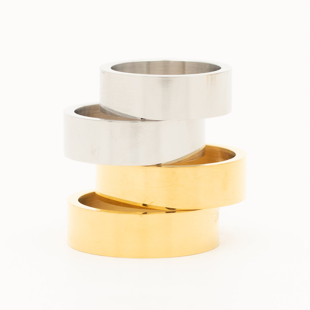 a ring in stainless steel is laying on the white table