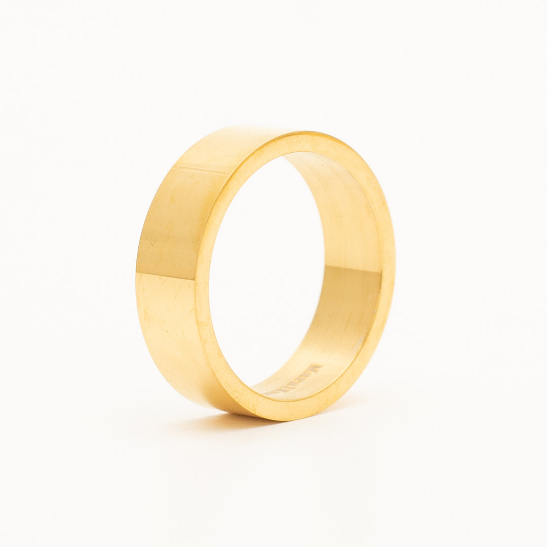 a ring in stainless steel is laying on the white table