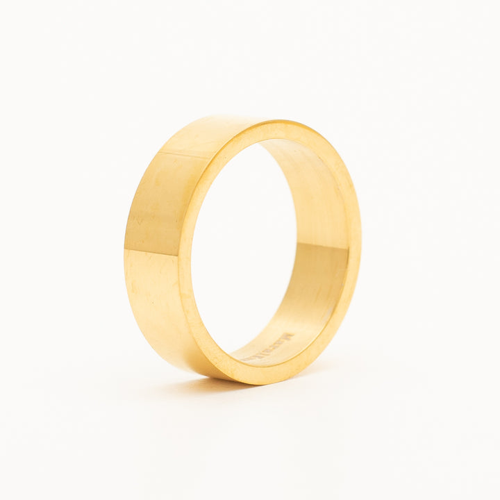 a ring in stainless steel is laying on the white table