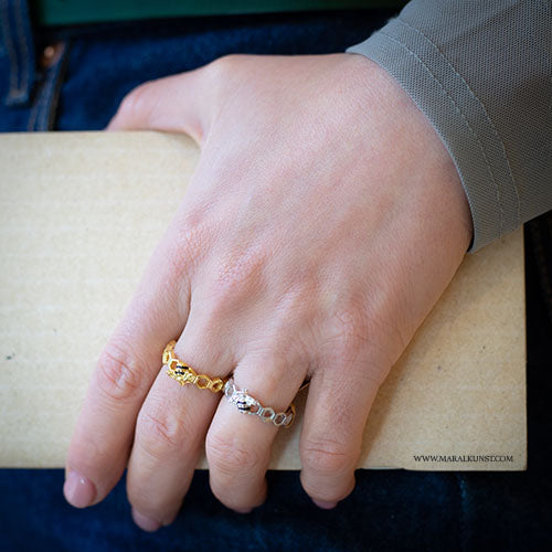 a women hand wearing 2 sterling silver rings have the shape of beehives