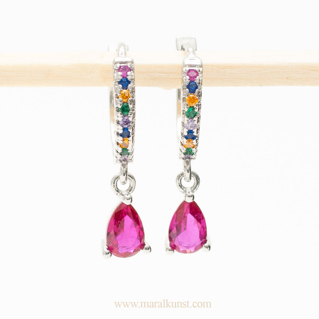 red stone earrings in sterling silver are hanging on a stick