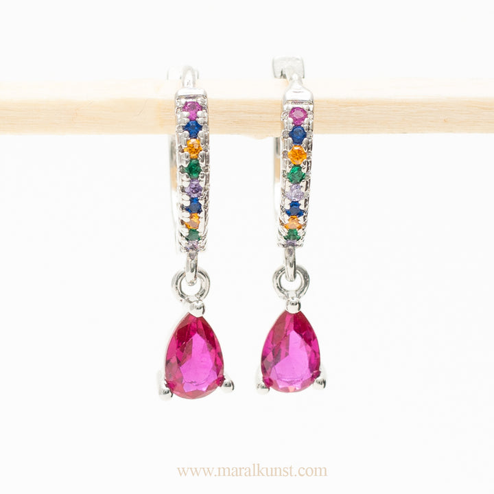 red stone earrings in sterling silver are hanging on a stick