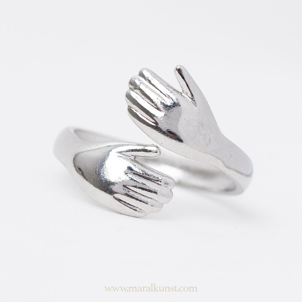 a hand shape ring in stainless steel is laying on the table