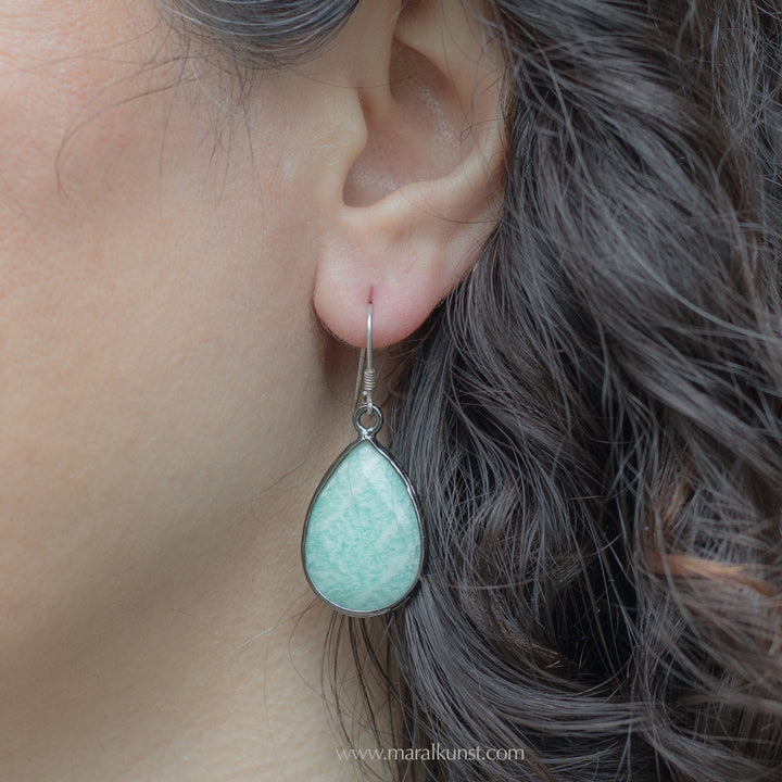 A women shows her ears wearing a pair of sterling silver 925 earrings 
